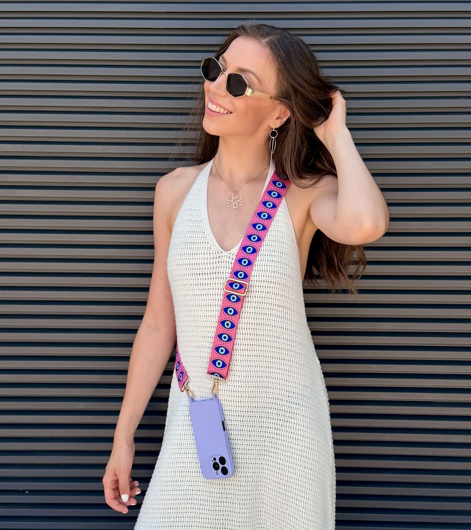 Strappy Set Art Evil Eye na modelke – ružový crossbody popruh na mobil a fialový kryt na iPhone.
