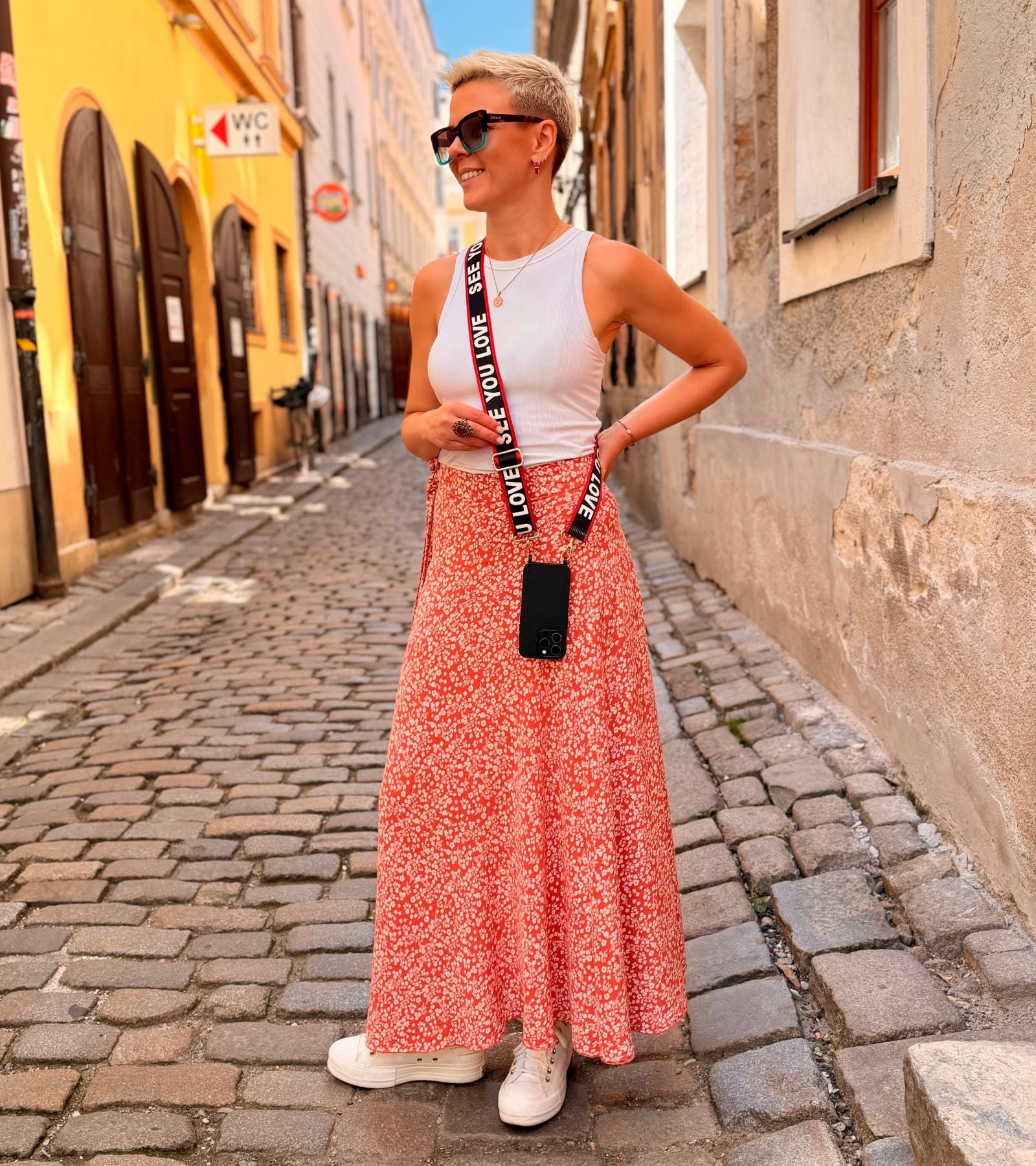 Strappy Set Art Love Statement na modelke – čierny crossbody popruh na mobil Love Statement a čierny kryt na iPhone ako štýlový módny doplnok.