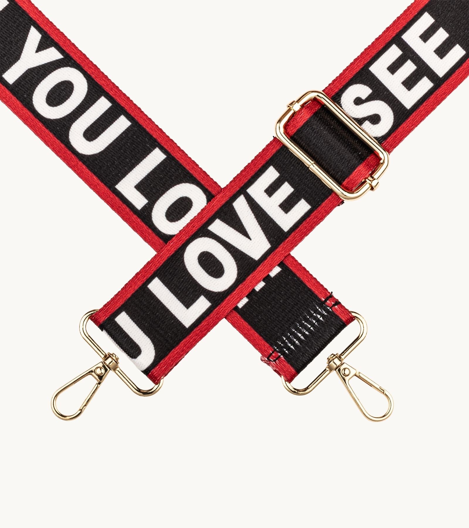 Detail crossbody popruhu na mobil Strappy Art Love Statement s typografickým dizajnom v čierno-červenej farebnej kombinácii.