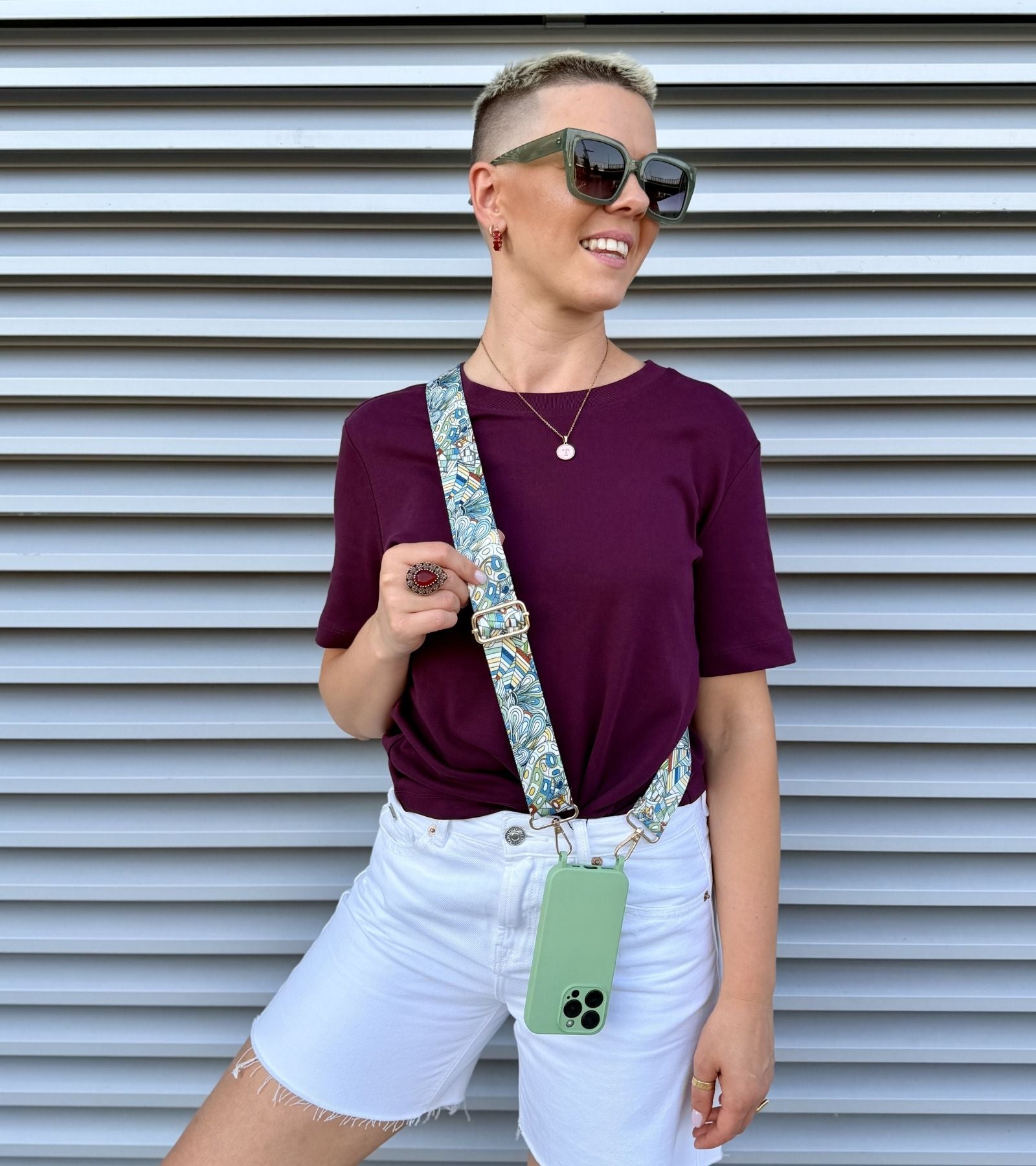 Strappy Set Art Ocean Mosaic na modelke – modro-zelený crossbody popruh na mobil Ocean Mosaic a zelený kryt na iPhone ako štýlový módny doplnok.