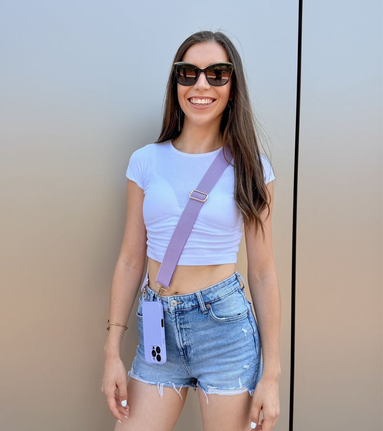 Strappy Set Line Lavender na modelke – crossbody popruh na mobil vo fialovej farebnej kombinácii a fialový kryt na iPhone ako štýlový módny doplnok.