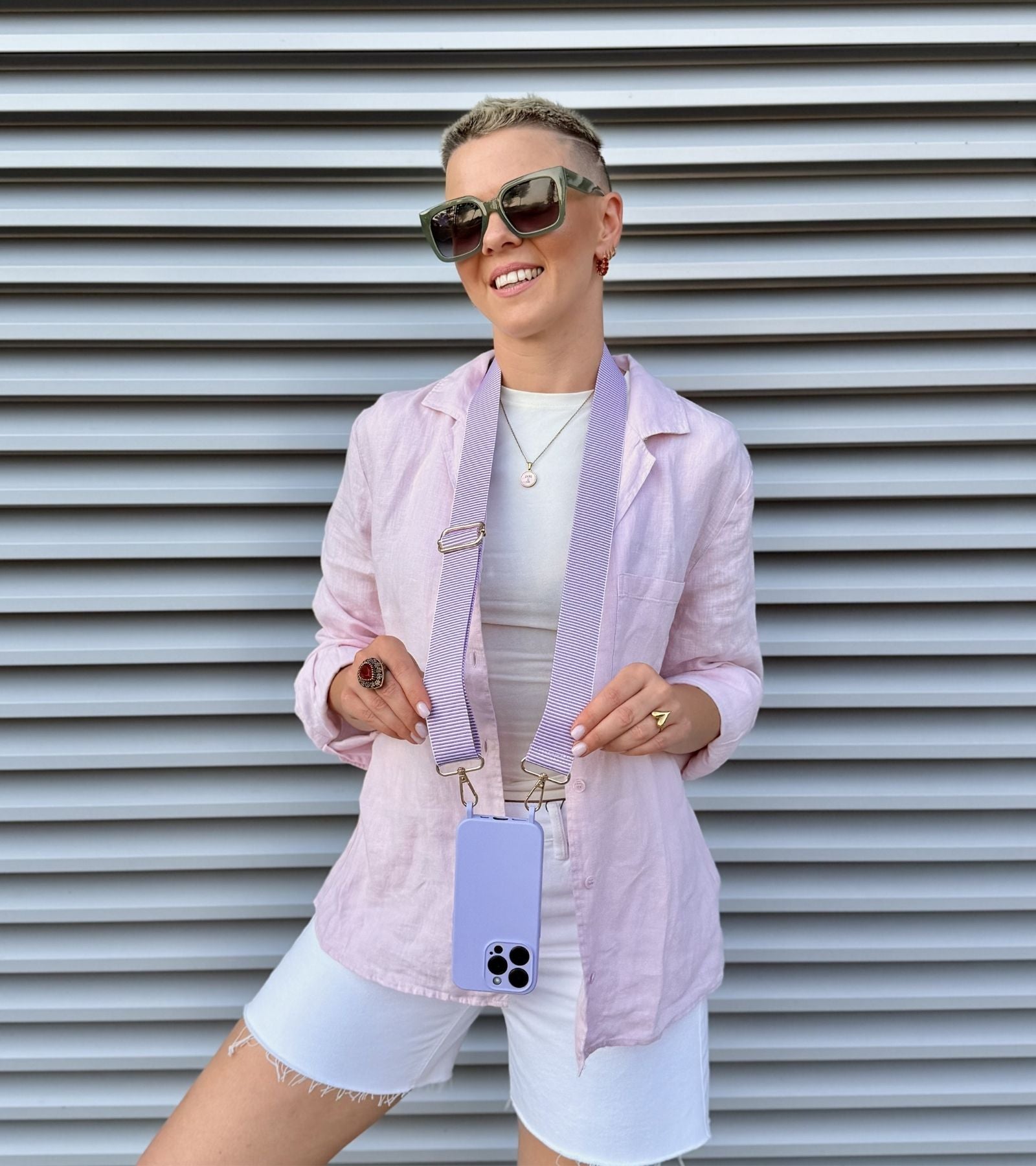 Strappy Set Line Lavender na modelke – crossbody popruh na mobil vo fialovej farebnej kombinácii a fialový kryt na iPhone pre voľné ruky počas dňa.