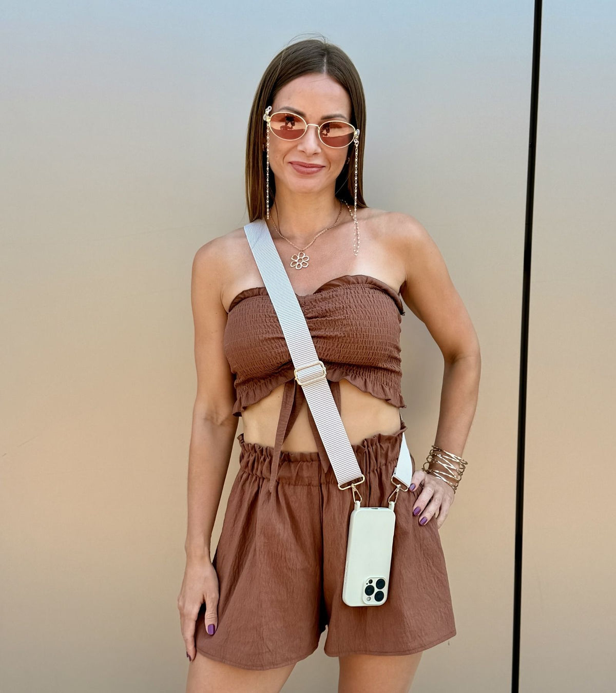 Strappy Set Line Soft Beige na modelke – crossbody popruh na mobil v béžovej farebnej kombinácii a béžový kryt na iPhone ako štýlový módny doplnok.