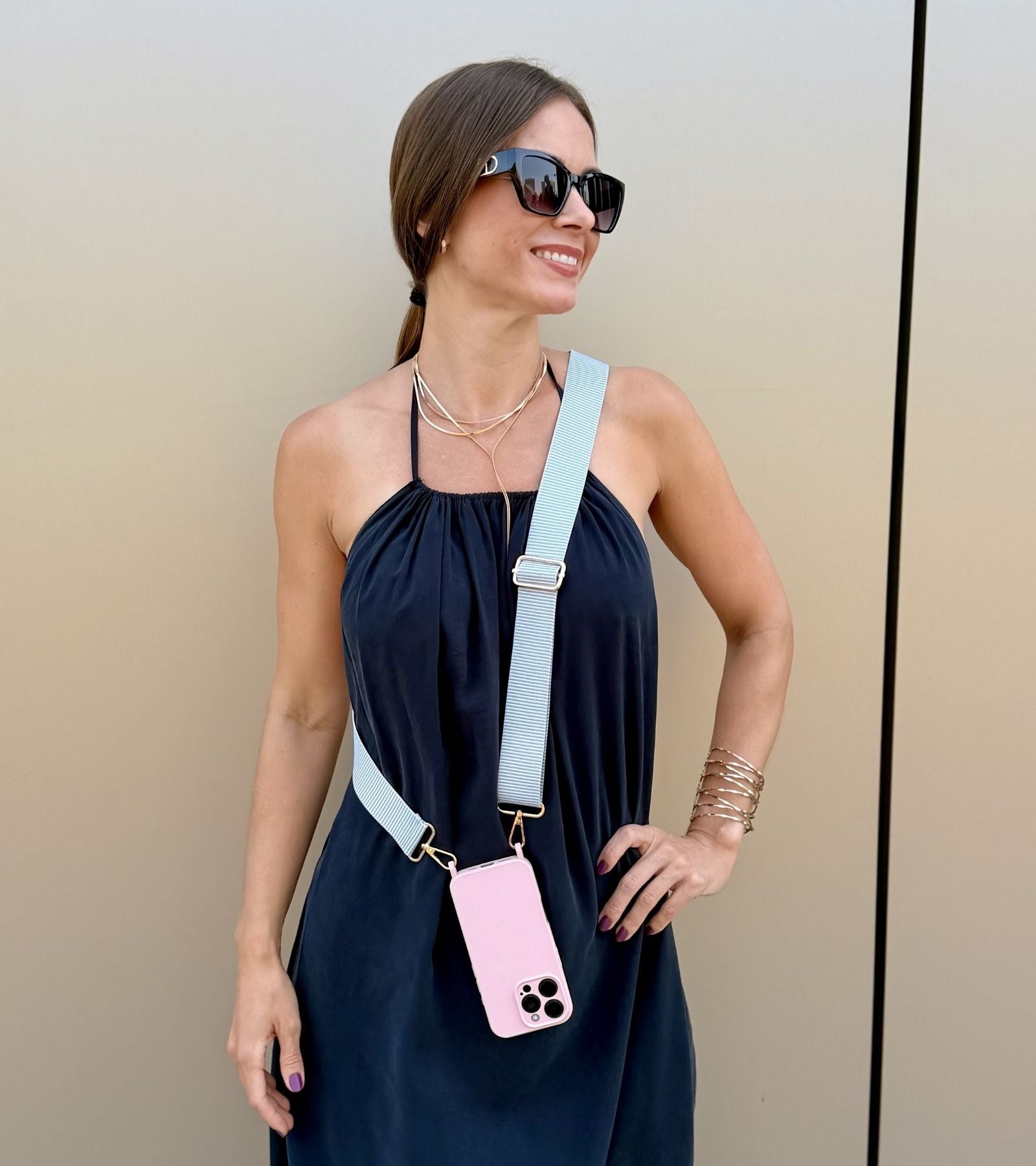 Strappy Set Line Soft Gray na modelke – crossbody popruh na mobil v sivej farebnej kombinácii a ružový kryt na iPhone pre každodenné nosenie.