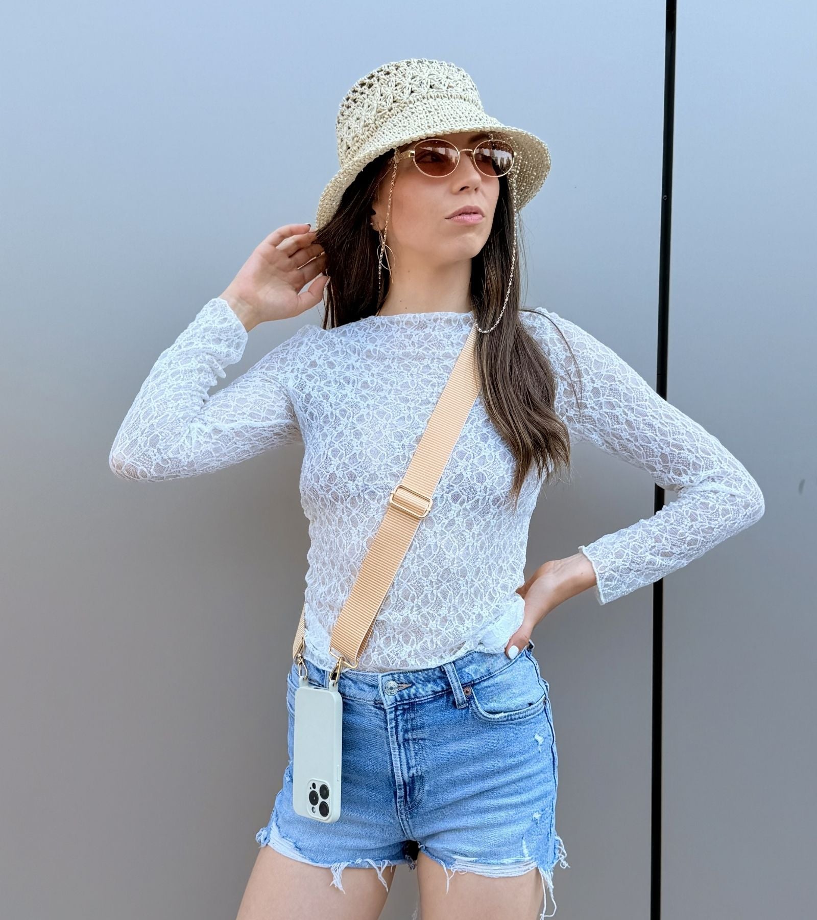 Strappy Set Line Sunny Yellow na modelke – crossbody popruh na mobil v žltej farebnej kombinácii a béžový kryt na iPhone ako štýlový módny doplnok.
