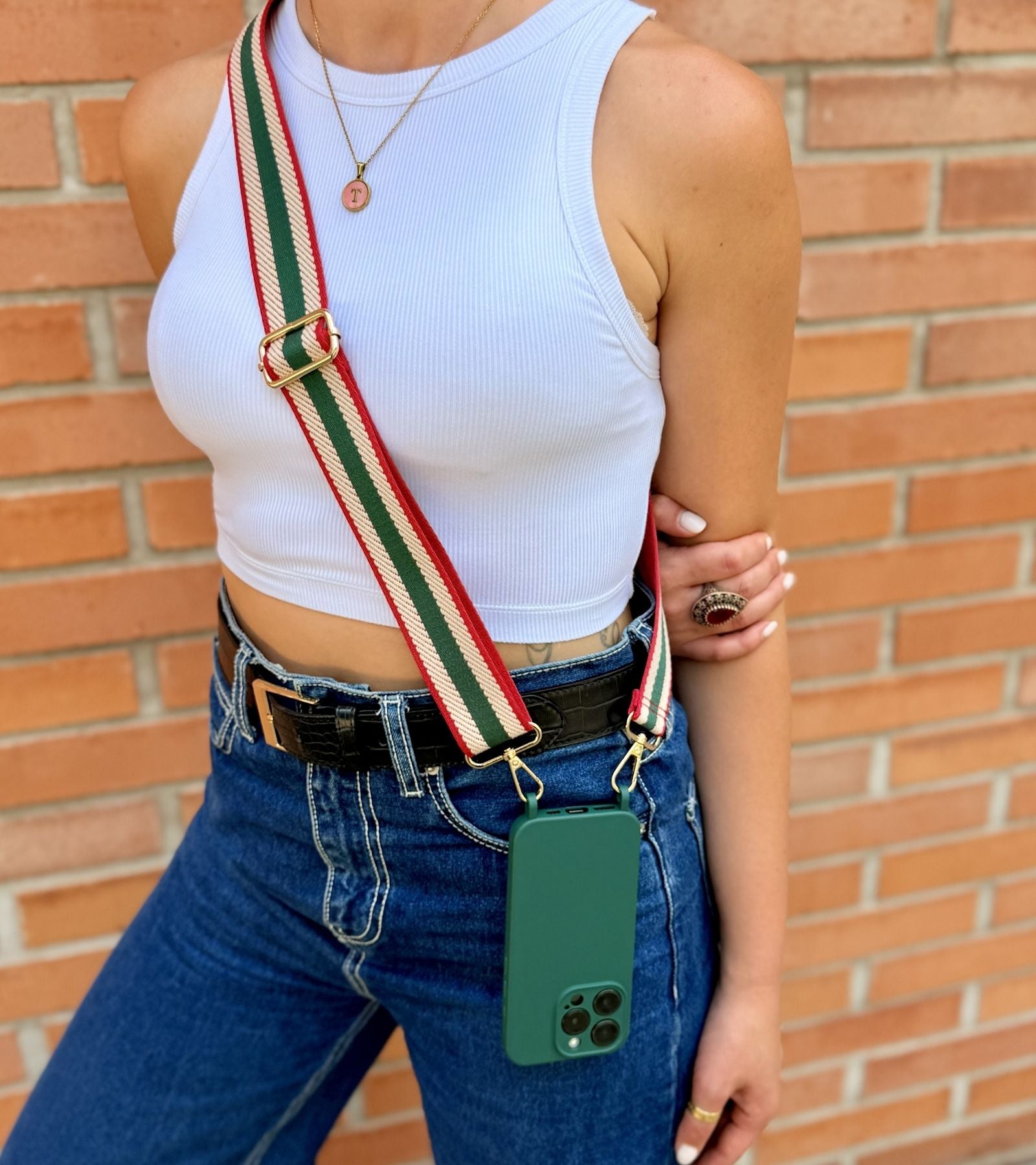 Detail Strappy Set Retro Forest Green – retro pásikavý crossbody popruh na mobil v zeleno-béžovo-červenej farebnej kombinácii a tmavozelený kryt na iPhone pre voľné ruky počas dňa.