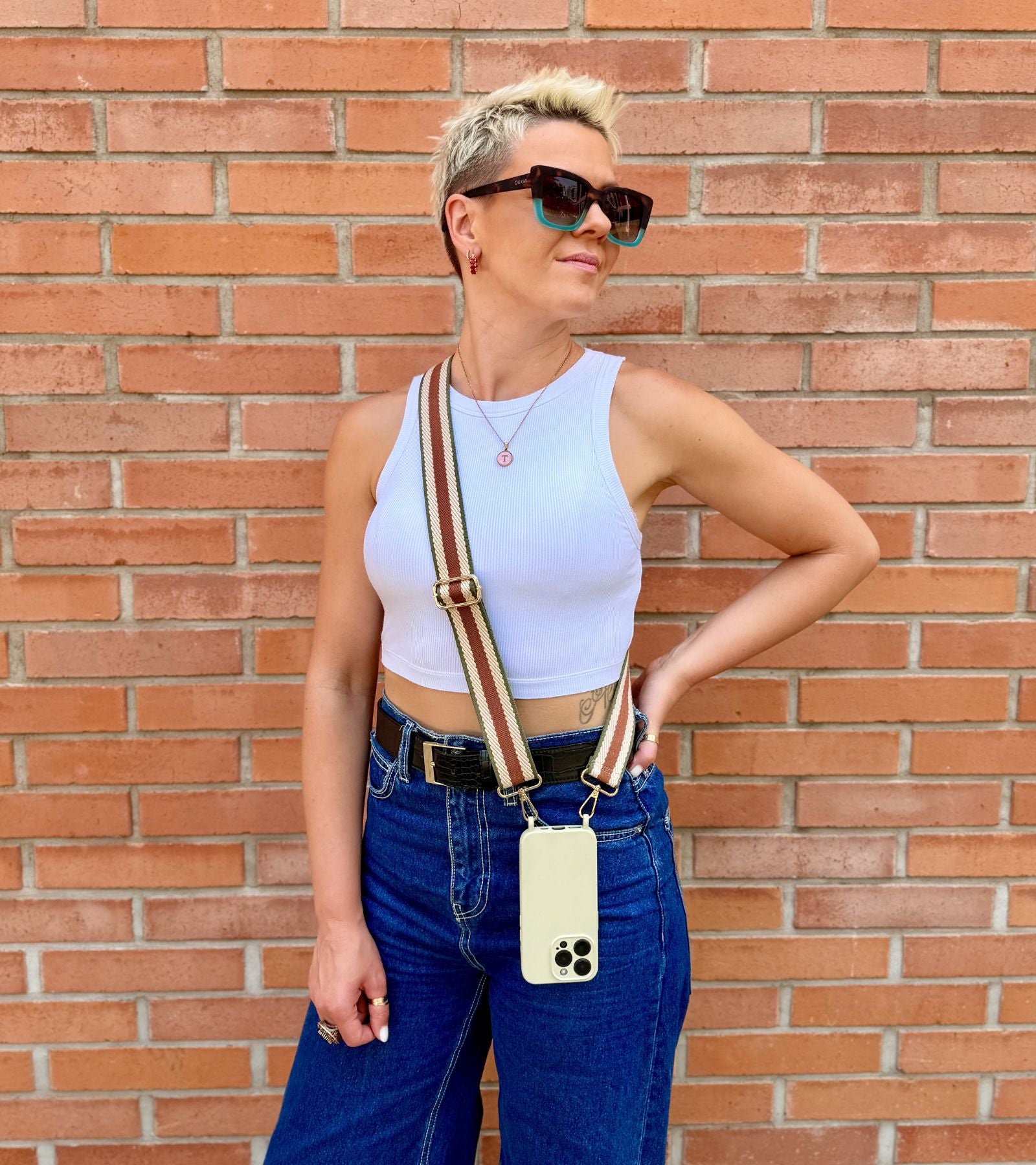 Strappy Set Retro Vintage Brown na modelke – retro pásikavý crossbody popruh na mobil v hnedej farebnej kombinácii a béžový kryt na iPhone ako štýlový módny doplnok.